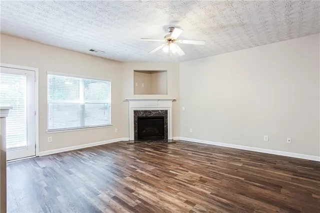 wooden floor fireplace and windows in an empty room