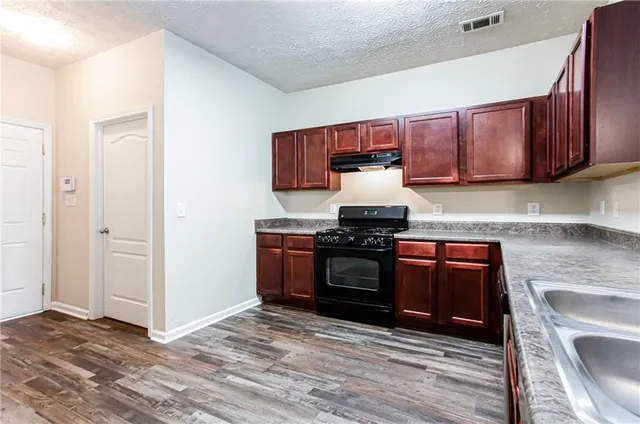 a kitchen with granite countertop a stove and a sink
