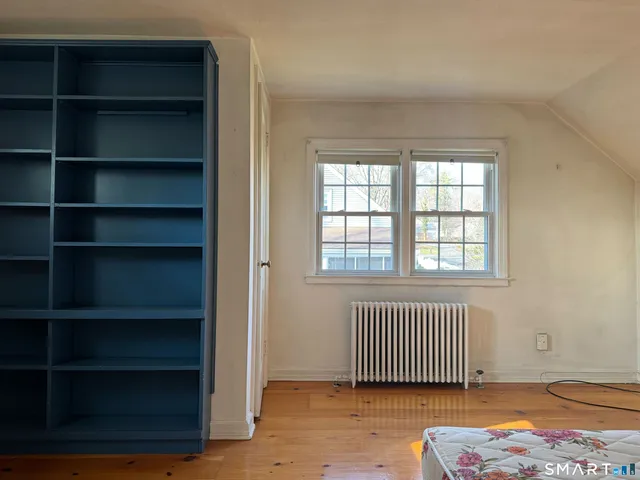 a view of empty room with wooden floor and cabinet