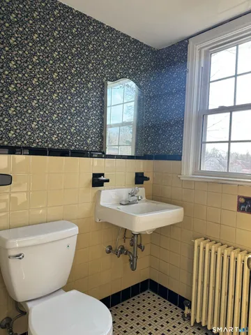 a bathroom with a sink toilet and window