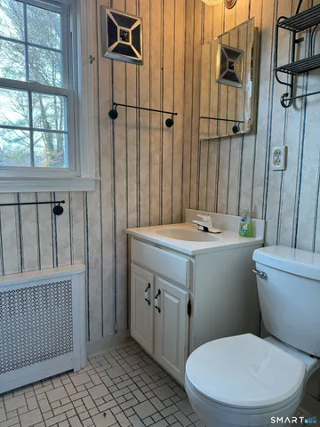 a bathroom with a sink a toilet a shower and a window