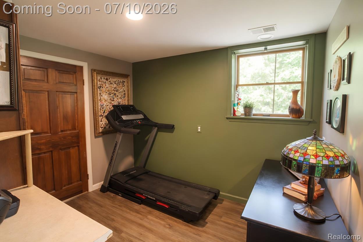 5278 Skelton Road Columbiaville, MI 48421 - Photo 43 of 64 Versatile room featuring wood-finish flooring, a wood-paneled door, and a single window with green trim