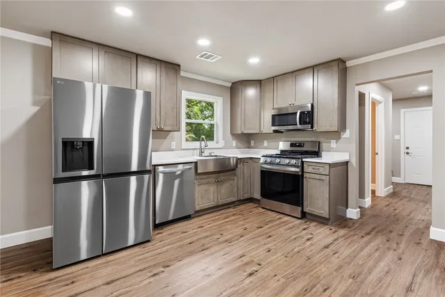a kitchen with stainless steel appliances granite countertop a stove a refrigerator and a sink
