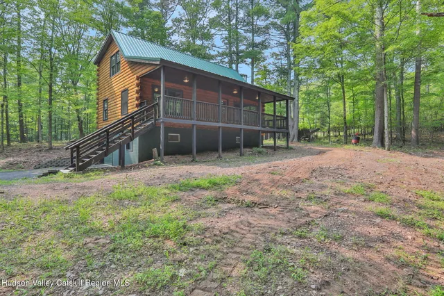 a view of a house with backyard and trees