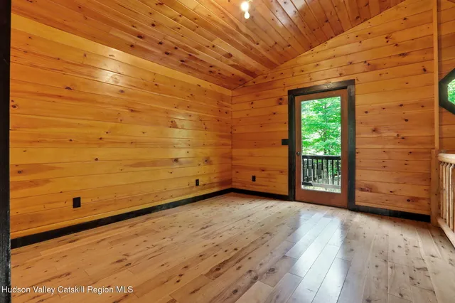 a view of a room with wooden walls and window