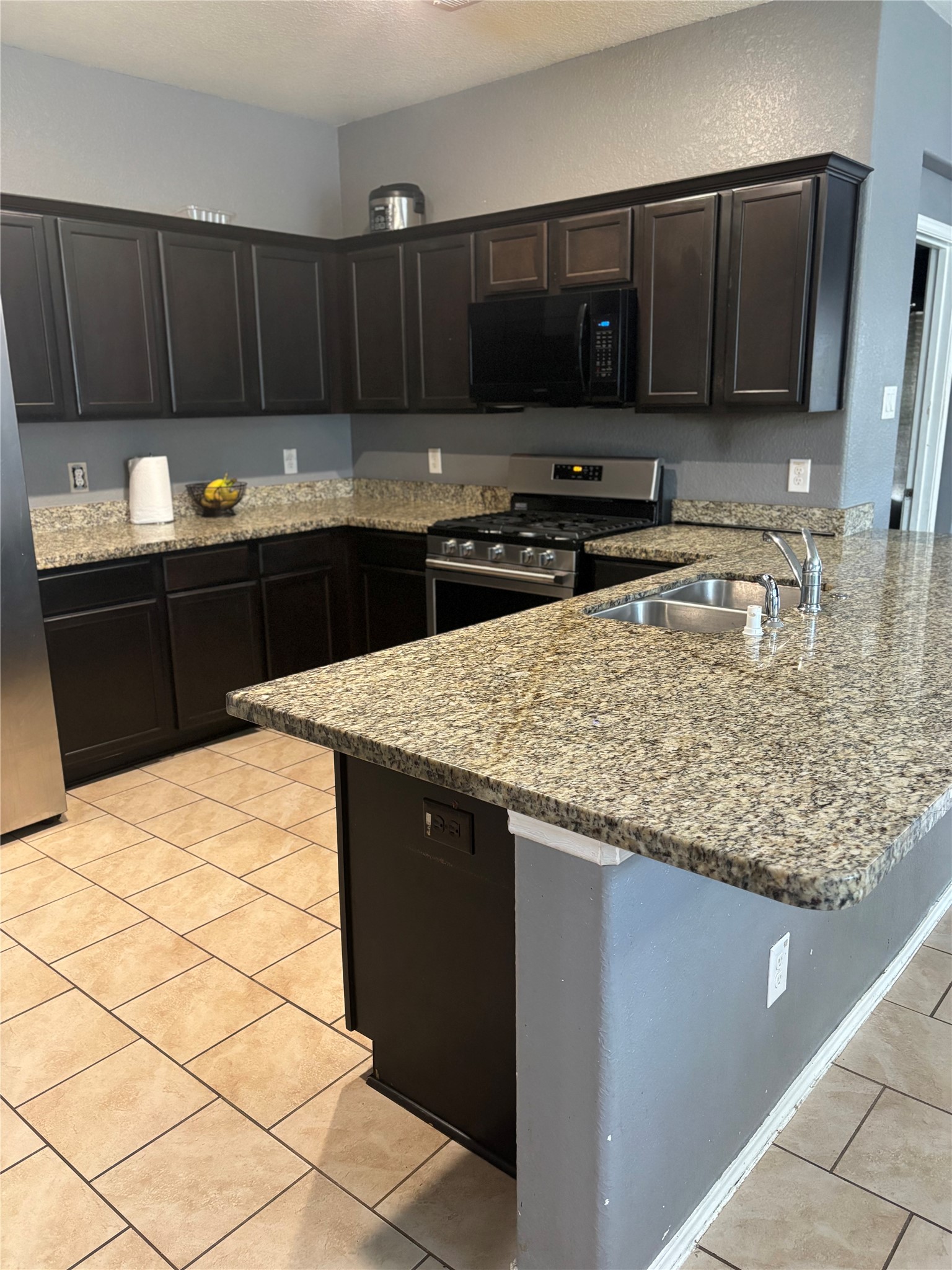 23502 Dukes Run Drive Spring, TX 77373 - Photo 4 of 6 a kitchen with granite countertop a sink and a stove top oven