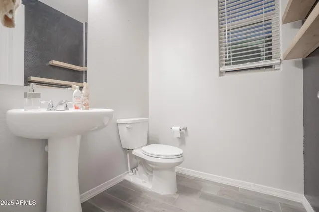 a bathroom with a sink toilet and a mirror