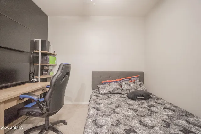 a bedroom with a bed a desk and chair