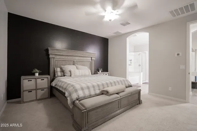 a spacious bedroom with a bed and a chandelier