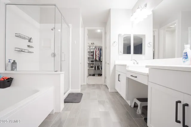 a large white bathroom with a bathtub and a sink