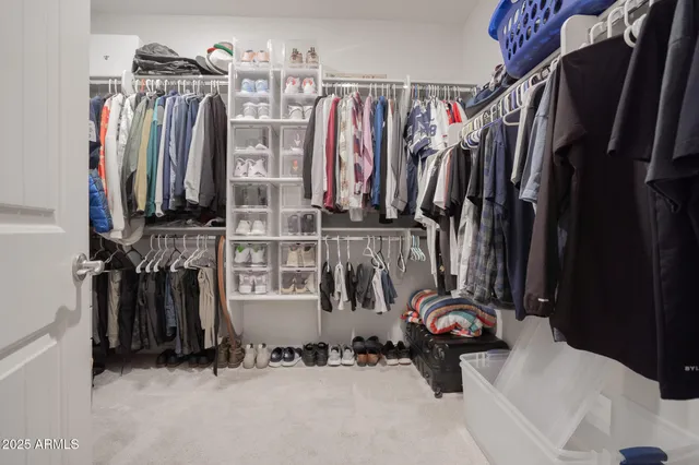 a view of walk in closet with clothes and shoes