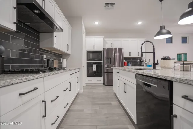 a kitchen with stainless steel appliances granite countertop a sink and cabinets