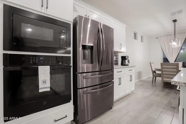 a kitchen with stainless steel appliances wooden cabinets and a refrigerator