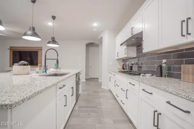 a large kitchen with kitchen island a sink stainless steel appliances and cabinets