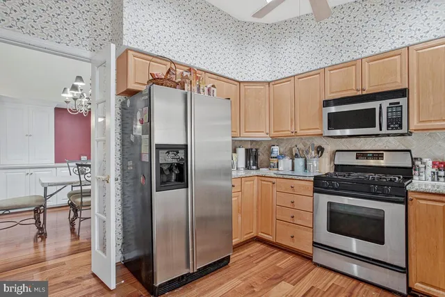 a kitchen with stainless steel appliances granite countertop a refrigerator stove and microwave