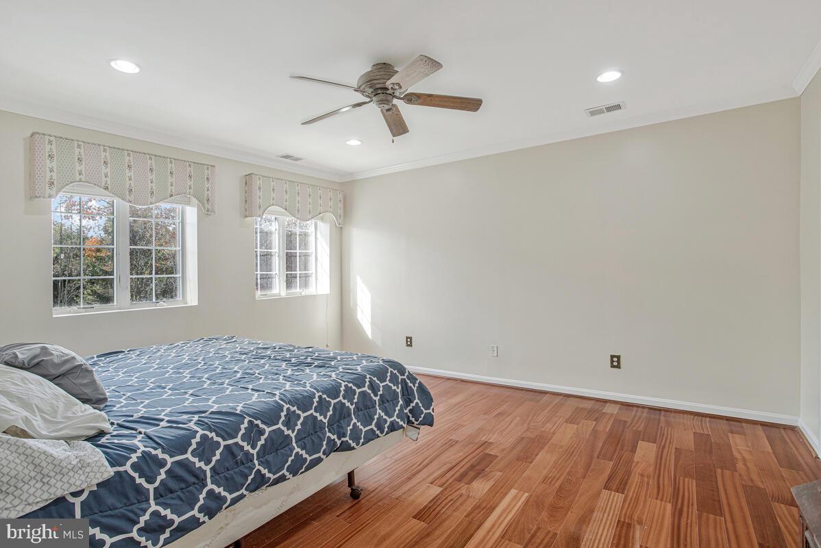 12300 Rosslare Ridge Road, Unit 508 Lutherville-Timonium, MD 21093 - Photo 28 of 40 a bedroom with a large bed and wooden floor