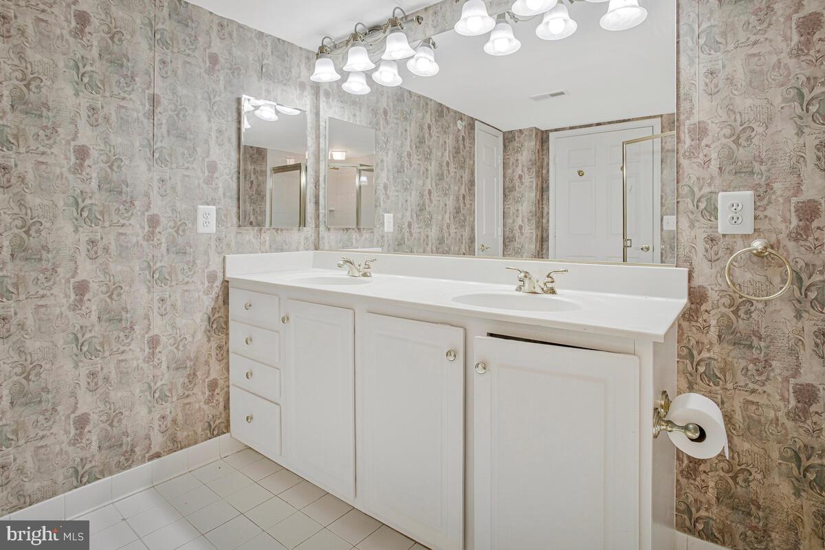 12300 Rosslare Ridge Road, Unit 508 Lutherville-Timonium, MD 21093 - Photo 30 of 40 a bathroom with a sink vanity and mirror