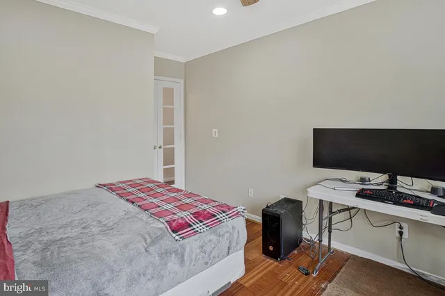 a bedroom with a bed and a computer on a desk