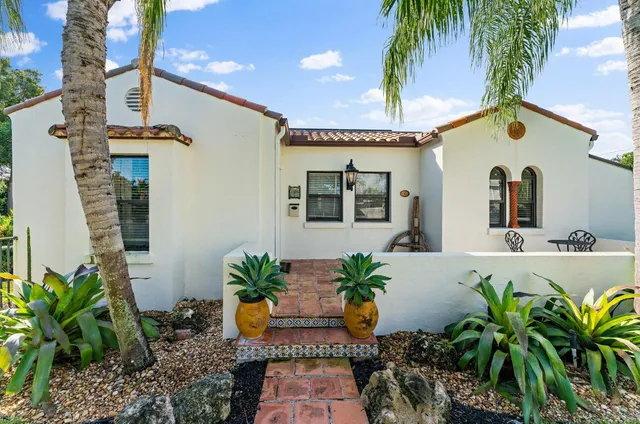 a living room with furniture a flat screen tv and a table