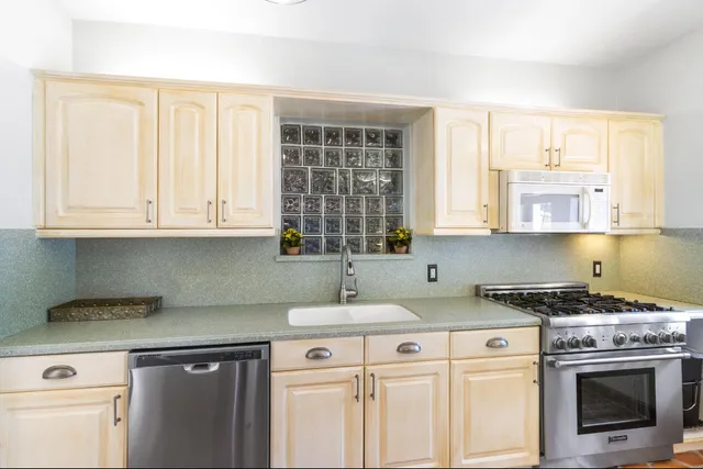 a spacious bedroom with a bed a chandelier and large window