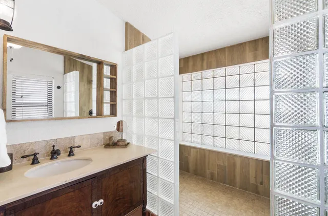 a bathroom with a sink a mirror and a shower