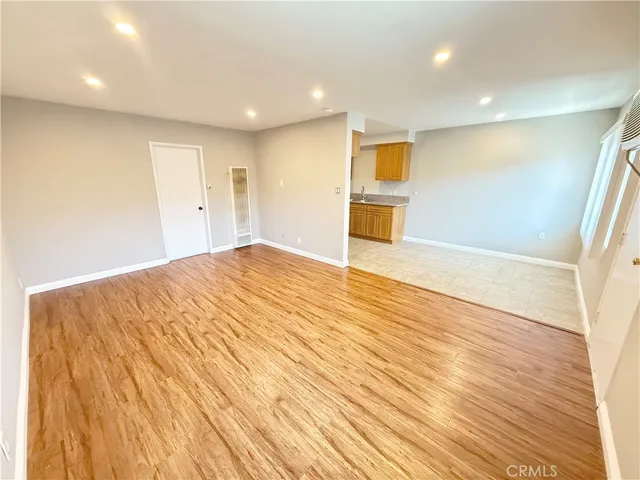a view of an empty room with wooden floor