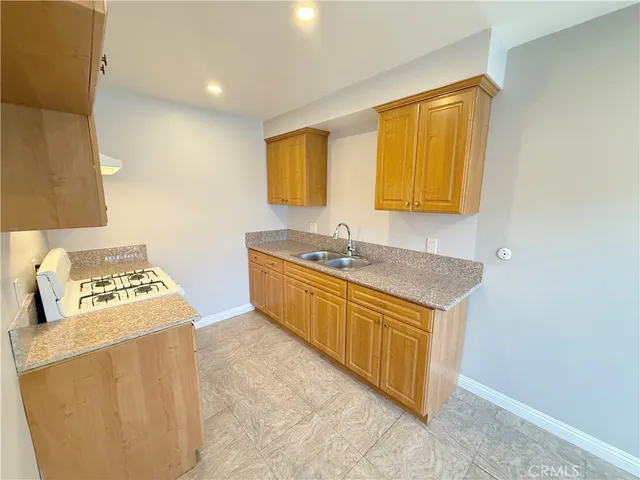 a kitchen with stainless steel appliances granite countertop a sink and a stove