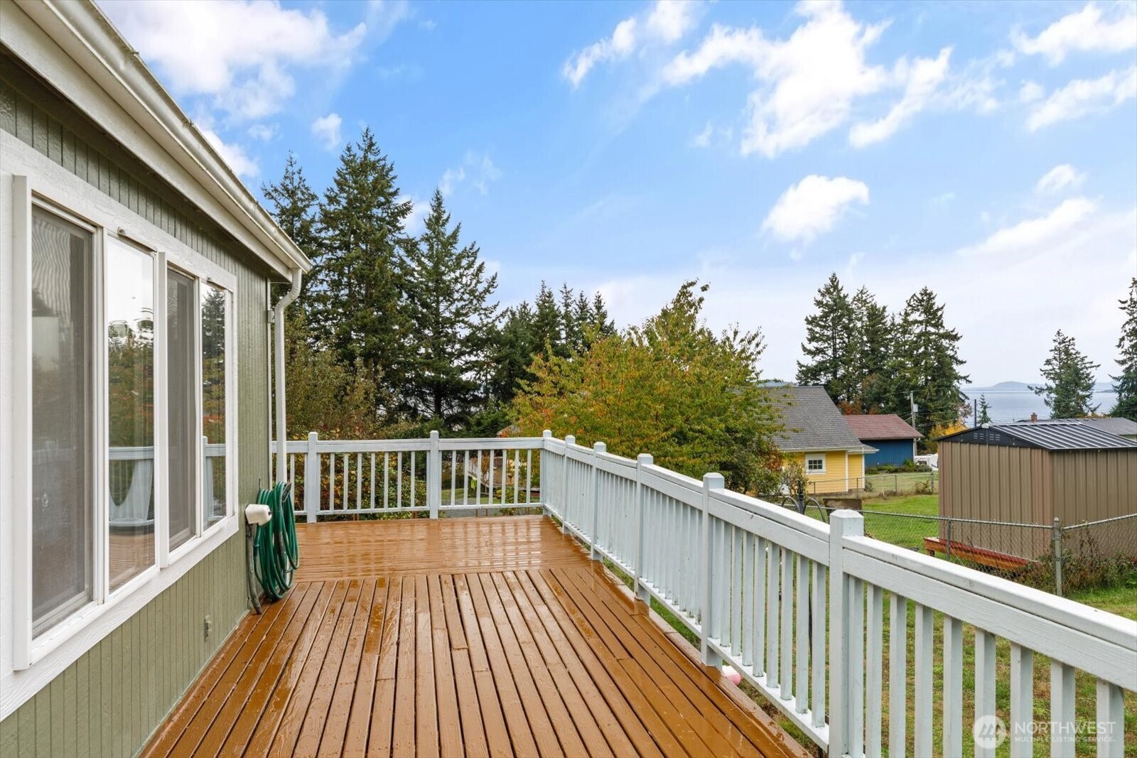 99 East Morris Road Coupeville, WA 98239 - Photo 5 of 32 a view of balcony with wooden floor and fence and trees