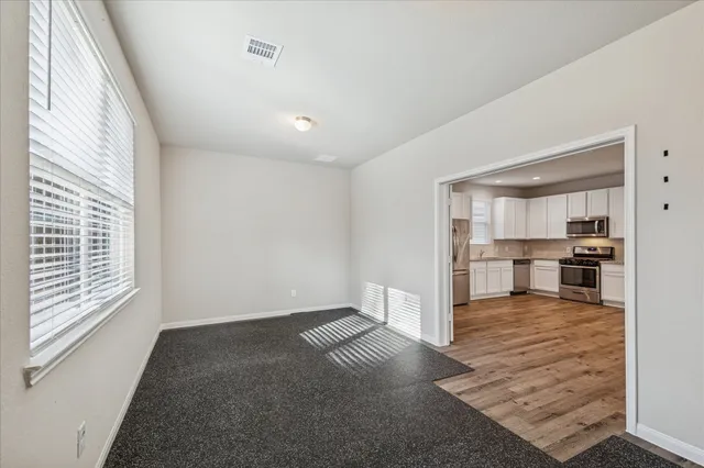 a view of kitchen and hall with wooden floor