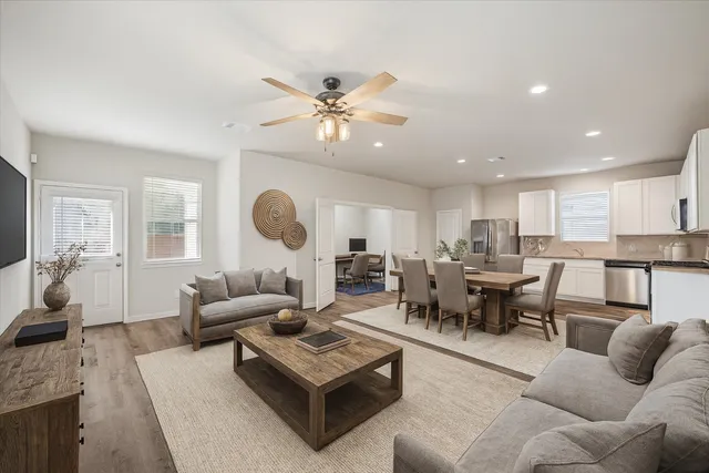 a living room with furniture kitchen view and a chandelier