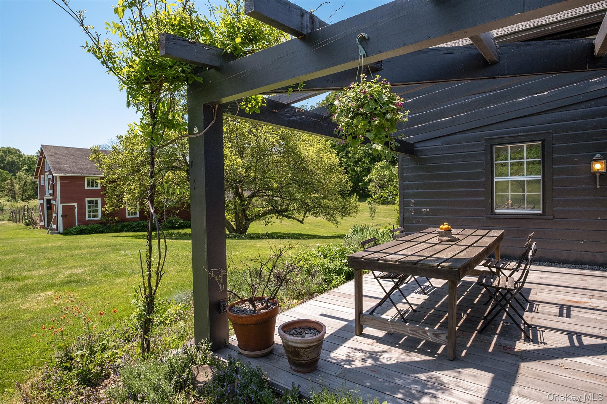 77 Upper Hook Road Rhinebeck, NY 12572 - Photo 4 of 48 a view of a patio with table and chairs potted plants with wooden floor