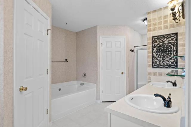 a bathroom with a tub sink and mirror