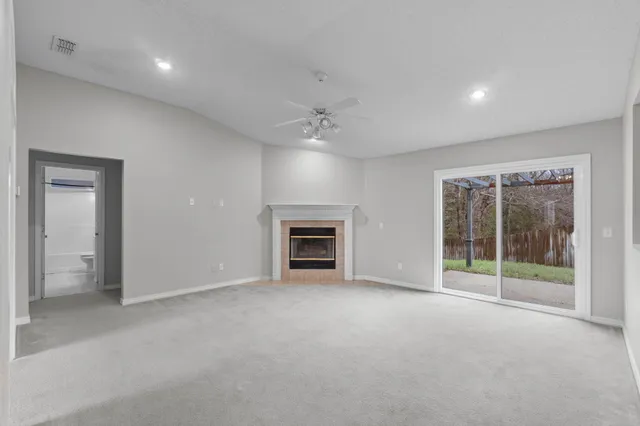 a view of an empty room with a fireplace and a window