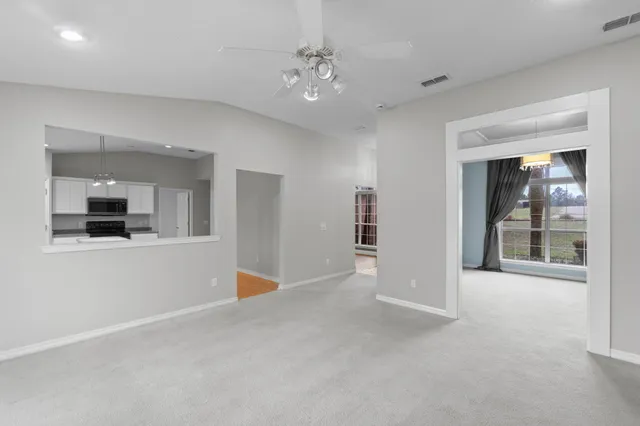 a view of a big room with windows and chandelier