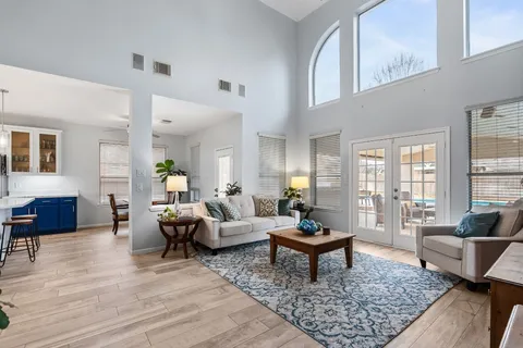 a kitchen with stainless steel appliances granite countertop a refrigerator a sink dishwasher a stove and a dining table with wooden floor