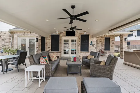 a living room with patio furniture and a large window