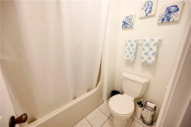 a bathroom with a toilet and a shower curtain