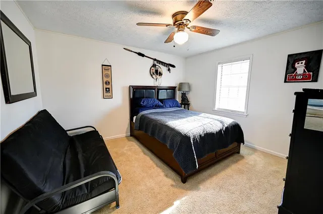 a bedroom with a bed a window and a chandelier
