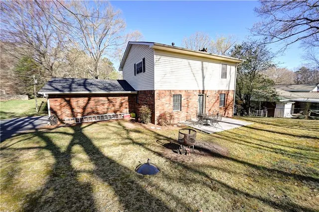 a view of a house with backyard and sitting area
