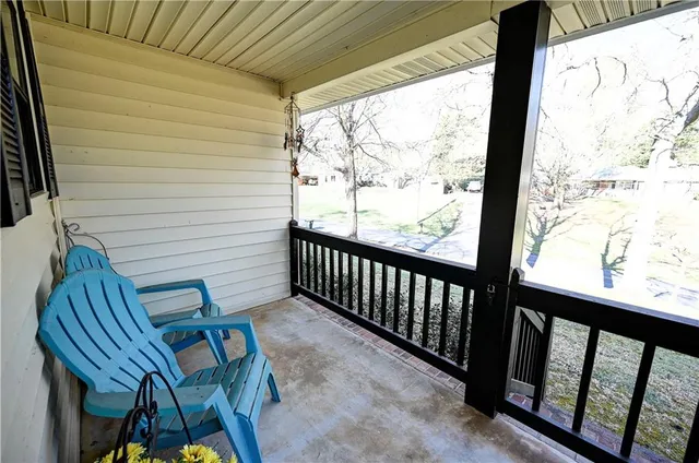 a view of a porch with furniture and wooden floor