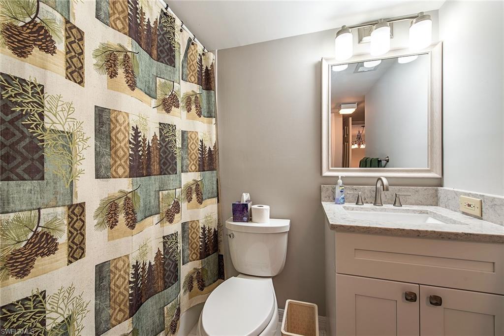 1672 Spoonbill Lane, Unit 1672 Naples, FL 34105 - Photo 11 of 12 a bathroom with a toilet sink and mirror