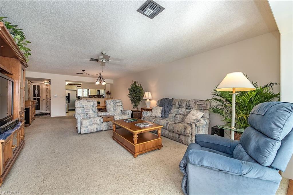 1672 Spoonbill Lane, Unit 1672 Naples, FL 34105 - Photo 3 of 12 a living room with furniture and a flat screen tv