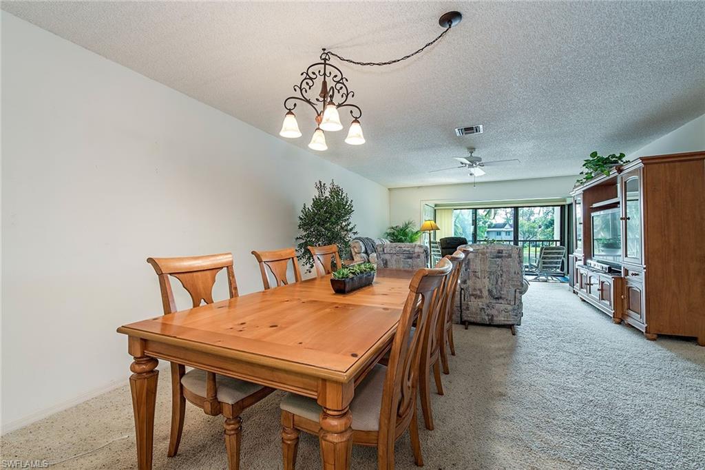 1672 Spoonbill Lane, Unit 1672 Naples, FL 34105 - Photo 4 of 12 a view of a dining room with furniture window and wooden floor