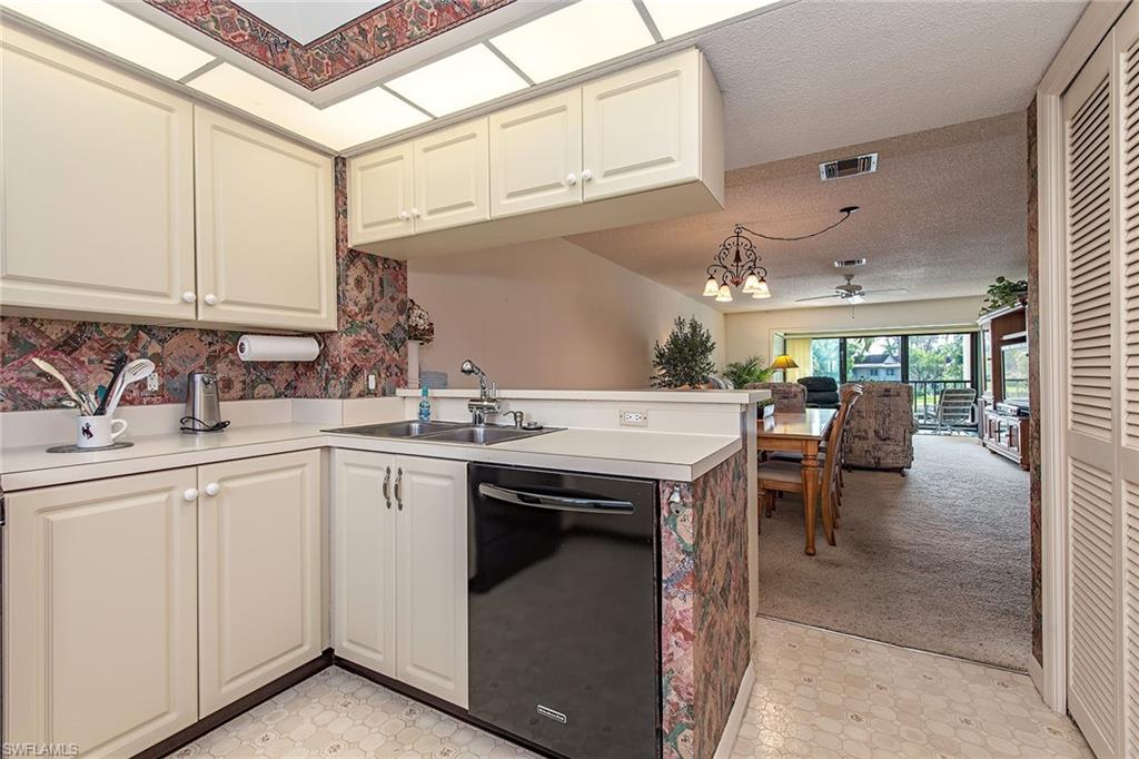 1672 Spoonbill Lane, Unit 1672 Naples, FL 34105 - Photo 7 of 12 a kitchen with a sink and cabinets
