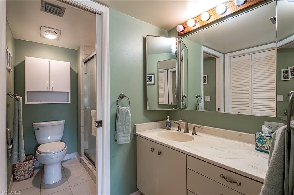 1672 Spoonbill Lane, Unit 1672 Naples, FL 34105 - Photo 9 of 12 a spacious bathroom with a sink a toilet and shower