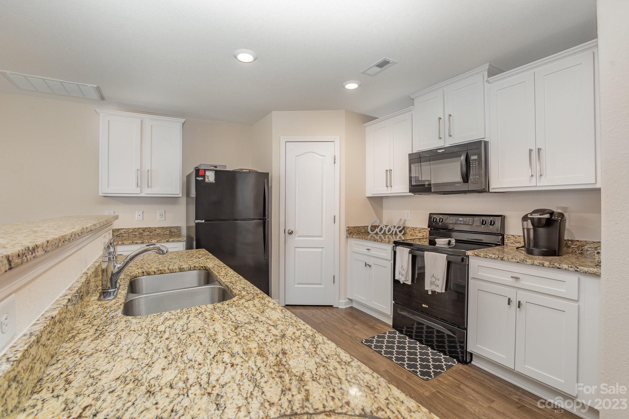 3201 Ellingford Road Charlotte, NC 28214 - Photo 14 of 29 a kitchen with granite countertop a sink stove and refrigerator