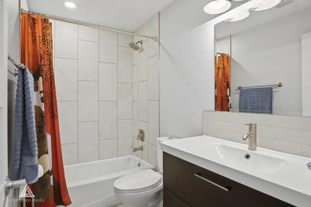 a bathroom with a bathtub shower sink vanity and toilet
