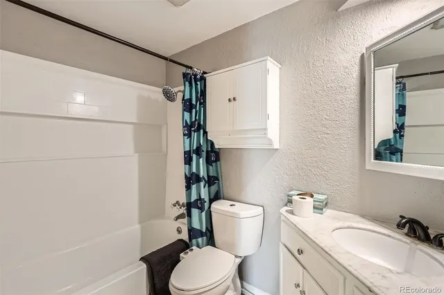 a bathroom with a sink toilet vanity and shower