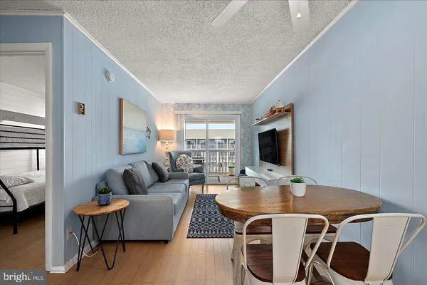 a living room with furniture a flat screen tv and kitchen view