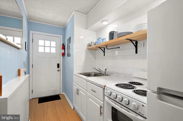 a kitchen with a stove and white cabinets